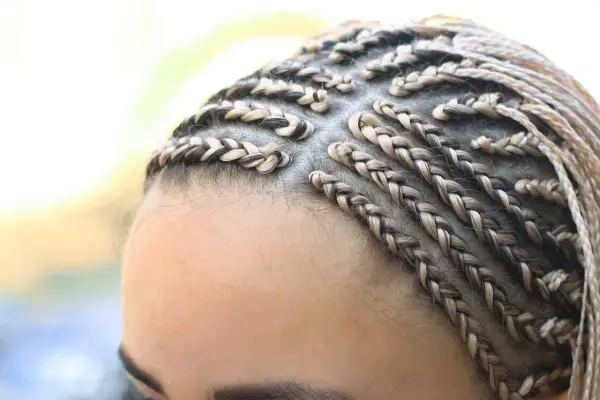 Primer plano de trenzas africanas rubias y castañas, peinado detallado y elegante.